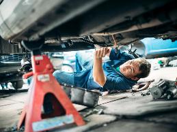 A mechanic with a bending restriction due to a low back impairment has problems accessing the engine compartment and low task areas of vehicles.